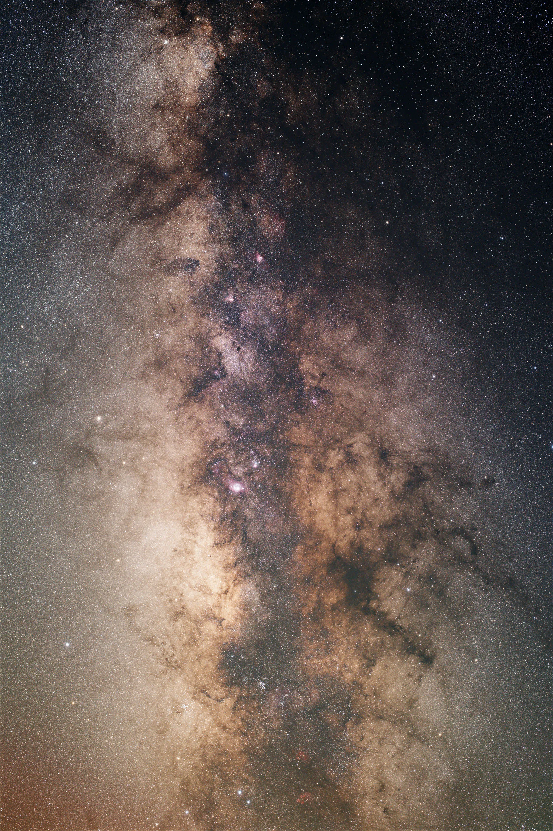 A close view of the Milky Way's core, dense with stars, glowing gas and dark dust lanes