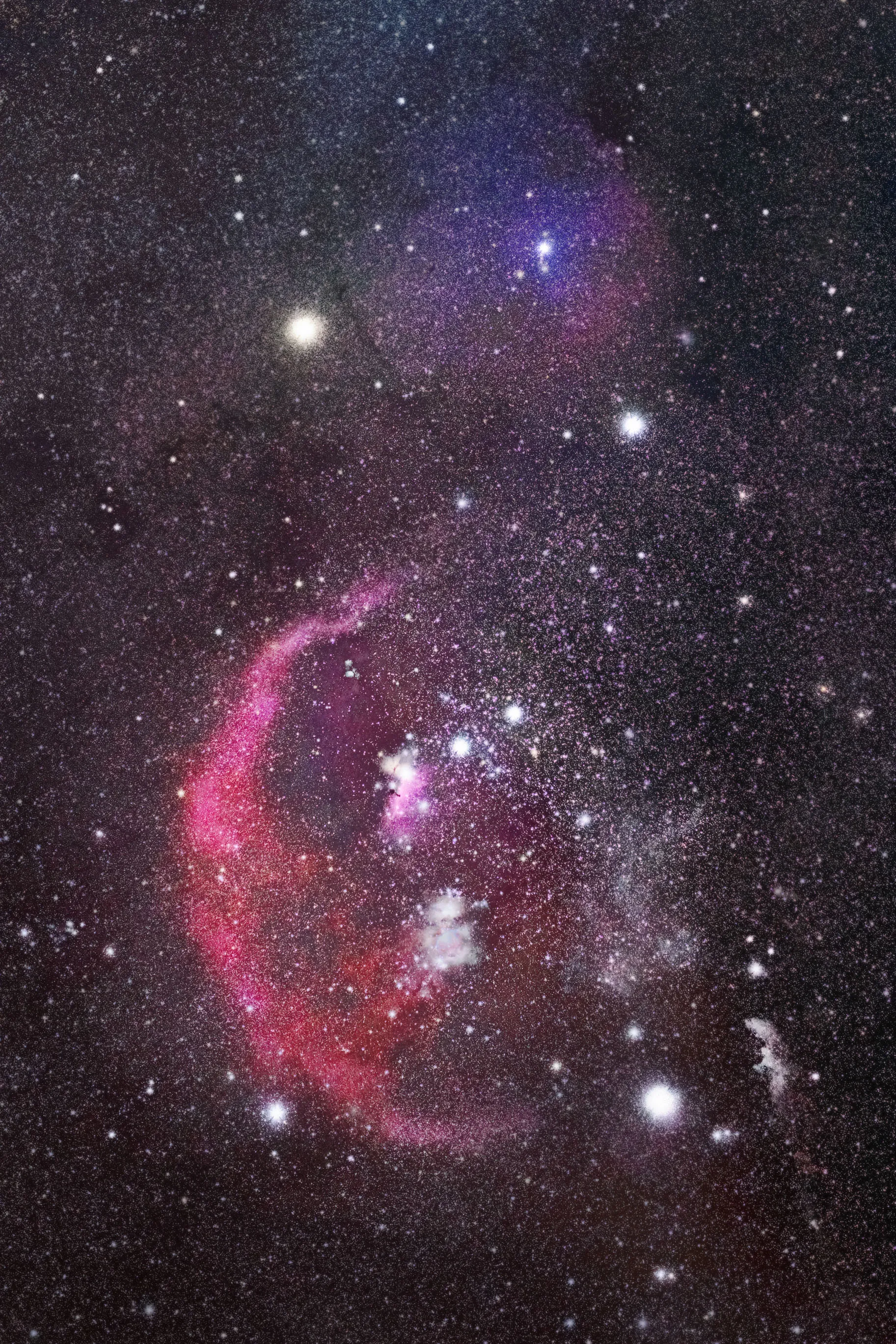 Red and violet nebulae glowing among bright blue-white stars in the constellation Orion, including the arc of Barnard's Loop